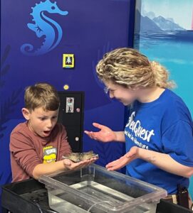 Excited kid holds marine life at SeaQuest
