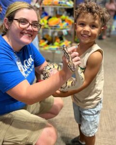 SeaQuest Employee helps a guest hold a snake