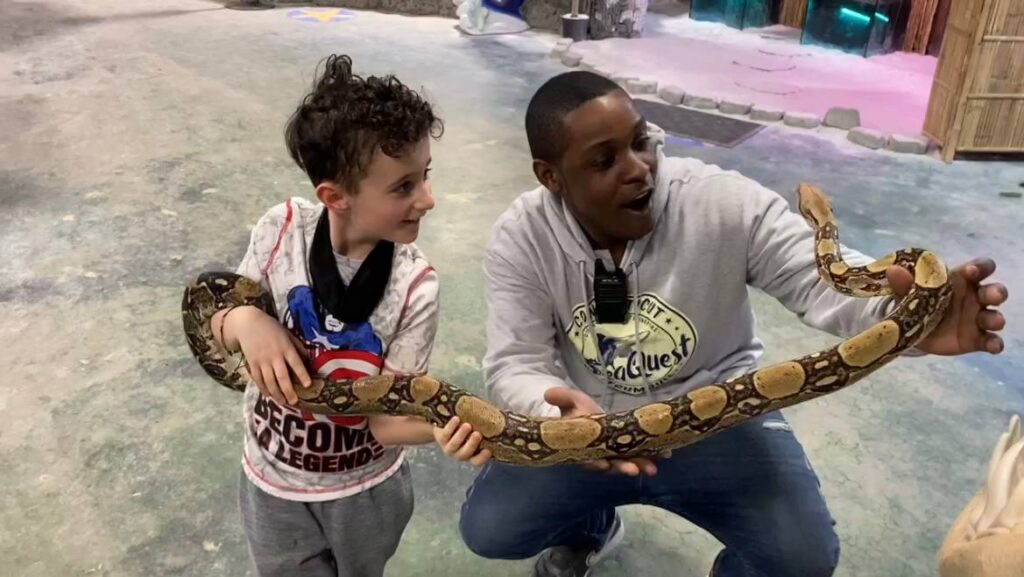 Son and Dad hold a snake at SeaQuest